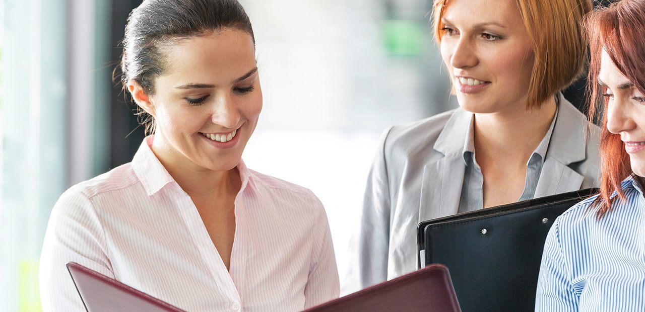 a woman looking at a document and smiling