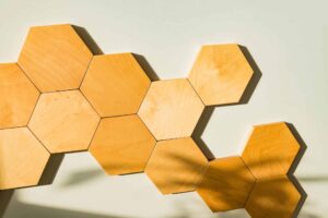 Light wooden hexagon tiles on a wall representing the Hexagon Method for organizing team ideas into visual strategy and alignment