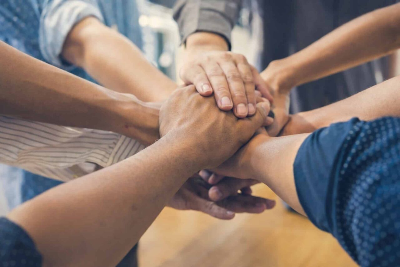 Diverse hands stacked together representing team unity and collaboration